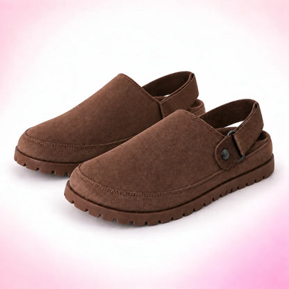 Dark brown strappy clogs with strap behind heel on a blush pink studio background