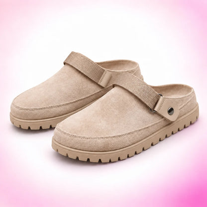 Khaki strappy clogs on a blush pink studio background