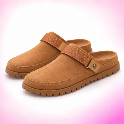 Orange strappy clogs on a blush pink studio background