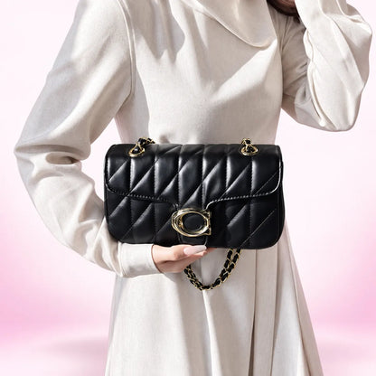 Black quilted crossbody bag with chain strap and oval gold-tone clasp
