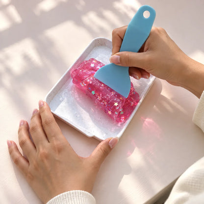 Hands preparing a squishy craft activity at a table